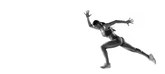 Fototapeta na wymiar Energy. Black and white portrait of professional female athlete, runner, jogger in action isolated on white background. Monochrome. Sport, beauty, power and style