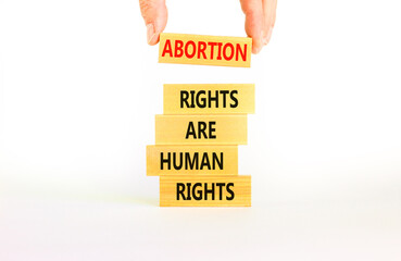 Abortion rights symbol. Concept words Abortion rights are human rights on wooden blocks. Businessman hand. Beautiful white background. Business medical abortion rights concept. Copy space.