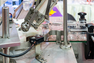 close up roller and chute with sensor for transport and control lid component of can cap seamer machine for manufacturing process in food or beverage filling and packing industrial