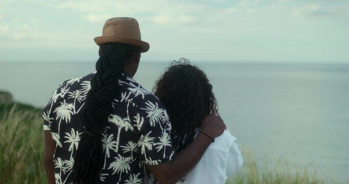 MS Couple embracing and looking at sea