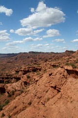 The steep canyon. Panorama view of the red desert, cliffs, orange sandstone formations and rocky mountains in the horizon in Sierra de las Quijadas national park in San Luis, Argentina.	
