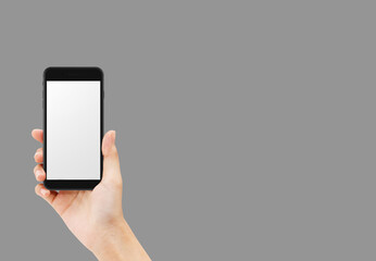 Hand holding black smartphone isolated on grey background