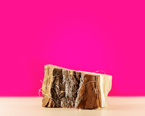 Empty wooden podium with lightening on a pink background. Product presentation. Beautiful background from natural materials for new product and promotion sale