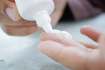 close up of hand using sunscreen cream 