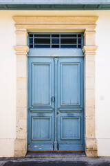 Old retro blue wooden front door in natural stone doorway 