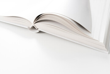 close-up view of blank page open hardback book on white desk