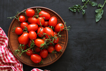 cherry tomatoes on a clay bowl, top view. ripe fresh vegetables. copy space. - obrazy, fototapety, plakaty