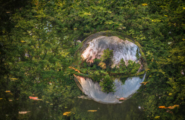 eine Glaskugel spiegelt sich in einem Teich