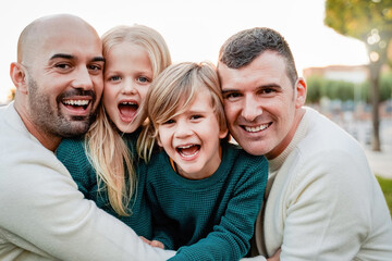 Fototapeta premium Gay male family having fun with children outdoors together in winter time - Lgbt community concept - Focus on left father face