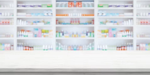 Photo sur Plexiglas Pharmacie Empty white wood counter top with blur pharmacy drugstore shelves background