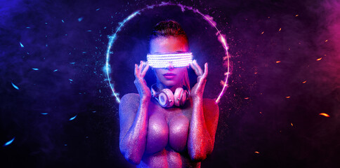 Hot topless DJ in neon lights with glasses and headphones. Portrait of sexy TDJ at club party.