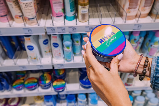 26 July 2022, Munster, Germany: Woman customer choosing Nivea cream among Various cosmetic products for sale in beauty store
