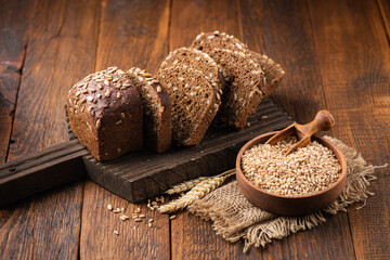 Rye bread with seeds on wooden background. Healthy bread