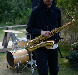 musician holding a saxophone. close up. front view.  Playing saxophone. man with saxophone standing...