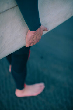 Detail of a hand on a surfboard.