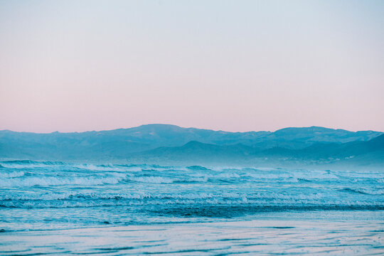 Waves roll at blue hour along the beach.