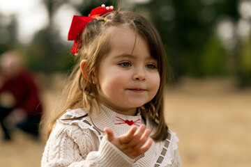 Outdoor portrait of an euphoric three years old little girl running, playing and happily enjoying...