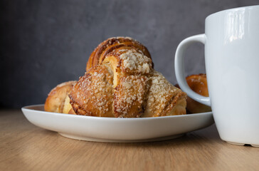 Fresh traditional polish pastry with poppy-seed filling and nuts. St. Martin's croissant. Rogal marciński or świętomarciński and white ceramic coffee cup or tea mug. - obrazy, fototapety, plakaty