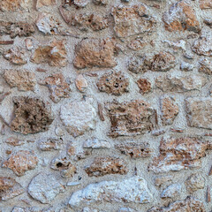old stone wall made of sandstone blocks of different sizes as the background