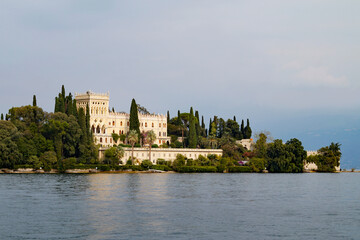 Obraz premium gorgeous mediterranean castle with a park full of beautiful exotic tropical trees and plants on Isola del Garda or Isola di Garda or Isola Borghese on lake Garda, Lombardy, Italy