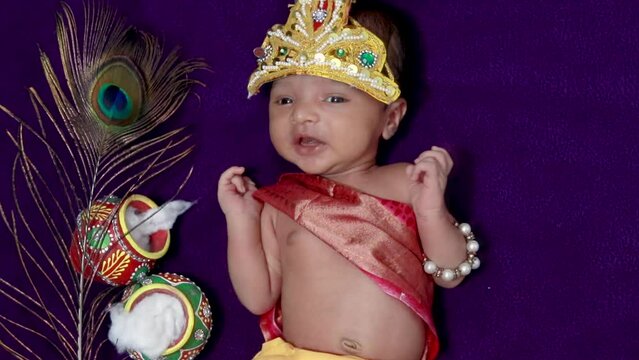 newborn baby boy in krishna dressed with props from unique perspective in different expression