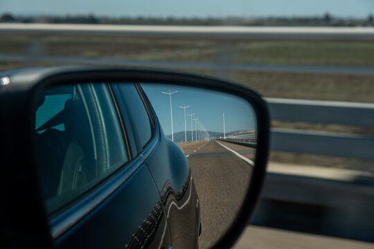 Car right side mirror on Portuguese highway, road landscape view on the car side mirror.