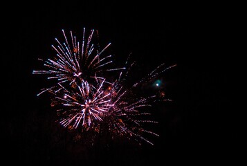 Huge fireworks explosions with Violet and golden colors over a party