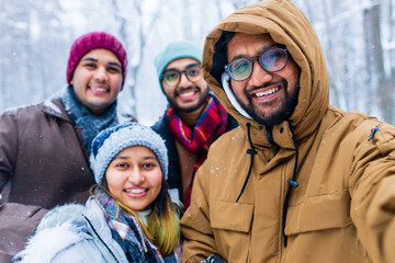 four people taking selfie shot outdoors at new year holidays