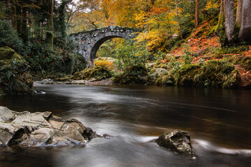 Foley's Bridge in autumn. Tollymore Forest Park scenic picture over the Shimna River. County Down,...