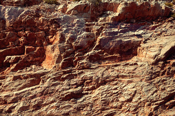Grungy cragged bumpy pitted cavity stone facade, split layer gap.Ruined cracked shattered worn rough hiking canyon.Old ragged grunge steep marble cliff. Grand vintage crannied damaged impressive gorge