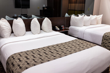 Bedroom room with two queen mattress beds in modern hotel motel room with white pillows sheets...