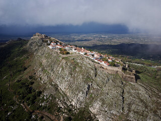 Fototapeta na wymiar Aerial drone view of Marvao, Historic Villages of Portugal. Castle and old town inside of a fortified wall on the cliff of a mountain. Rural tourism. Holidays. Best destinations in the world. 