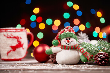cheerful snowman in a knitted hat on a Christmas background.