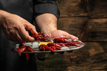 male hands holding boiled crayfish. Concept beer appetizer, delicacy, crayfish meat. Long banner...