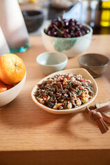 Bowls with dried fruits, tangerines and cherries
