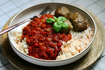 Rice with meatballs and tomato sauce.