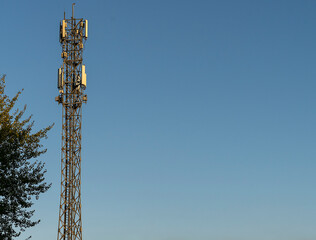 Telecommunication tower with antennas against blue sky. Mobile phone tower
