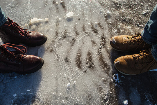 Winter is coming. Winter Female boots and male boots on rough slipper ice surface. Love concept