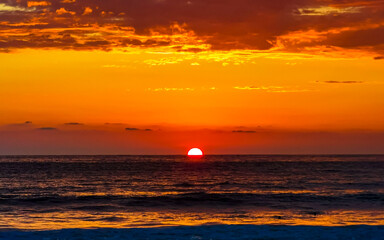 Colorful golden sunset big wave and beach Puerto Escondido Mexico.