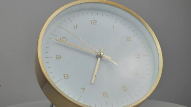 Timelapse of vintage clock with full turn of time hands at 6 pm or am on wooden background. Old Retro wall clock with white circular dial. Old-fashioned antique clock. Arrows second, minute, and hour