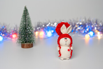 Handmade knitted bunny on a New Year's blurred background