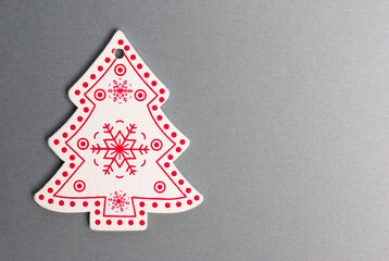 Close-up painted wooden figurine of a Christmas tree on a gray background. Clipping path. Copy space