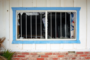 Broken window smashed out of vacant convenience store