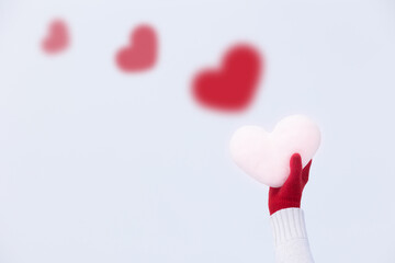 an icy heart in beautiful, red knitted gloves. Abstract greeting card, conceptual love, romance, February 14, Valentine's Day, Christmas