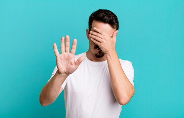 covering face with hand and putting other hand up front to stop camera, refusing photos or pictures