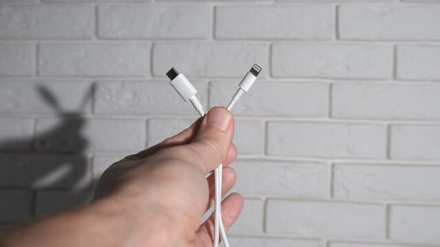 Universal USB Type-C plug. Man throws away Lightning plug and leaves USB Type-C