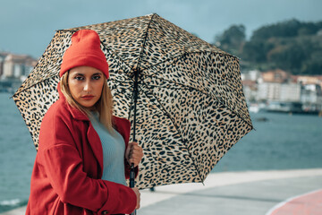 beautiful woman with umbrella on sea promenade