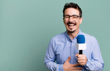 adult man laughing out loud at some hilarious joke with a microphone. presenter or journalist...