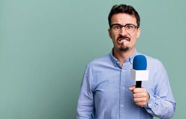 adult man looking puzzled and confused with a microphone. presenter or journalist concept