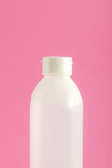 white plastic bottle on pink background